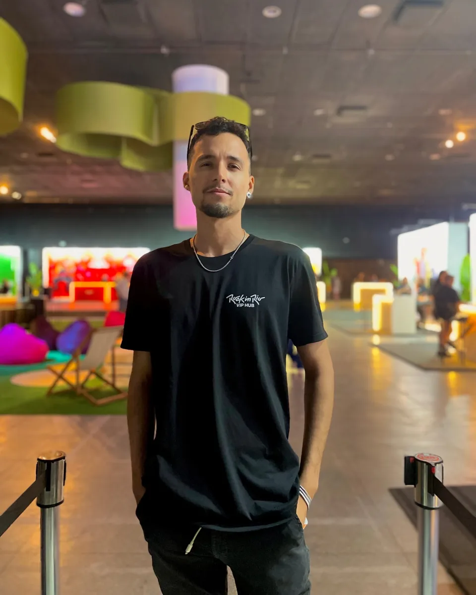 Profissional de controle de acesso na entrada do VIP Hub do Rock in Rio, entre os pedestais de fila