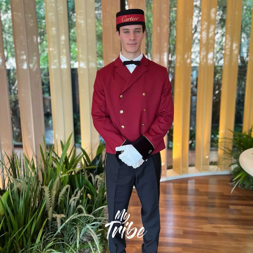 Modelo de recepção com uniforme de mensageiro e luvas brancas em evento da Cartier