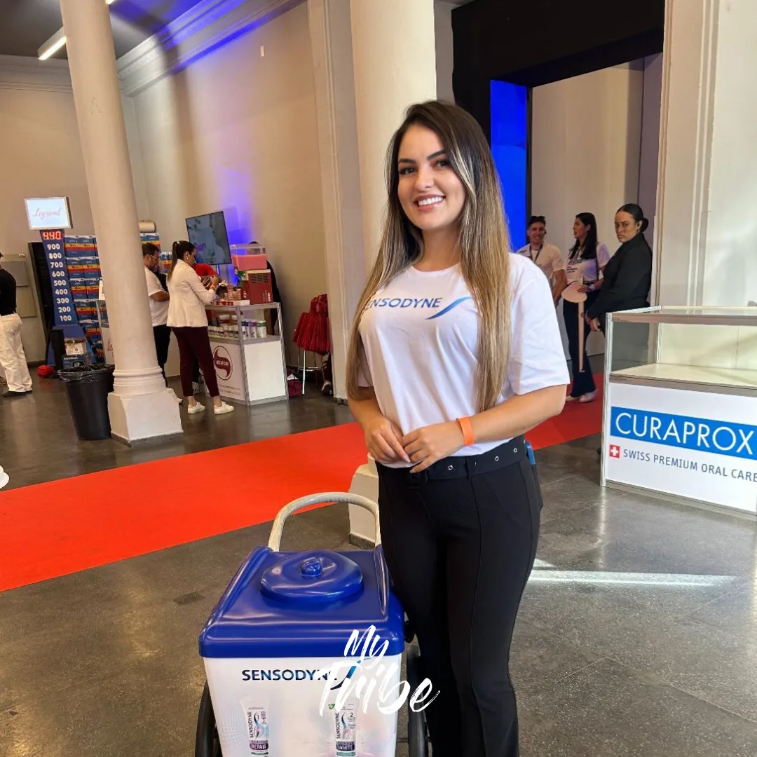 Promotora com camiseta da Sensodyne e carrinho de amostras em congresso de odontologia