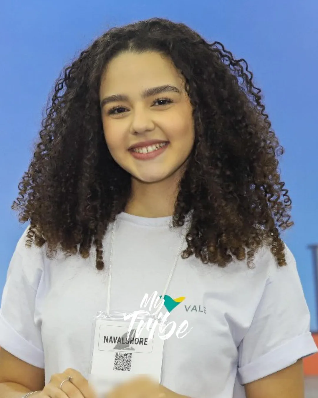 Recepcionista sorrindo com crachá da feira Navalshore, no Rio de Janeiro