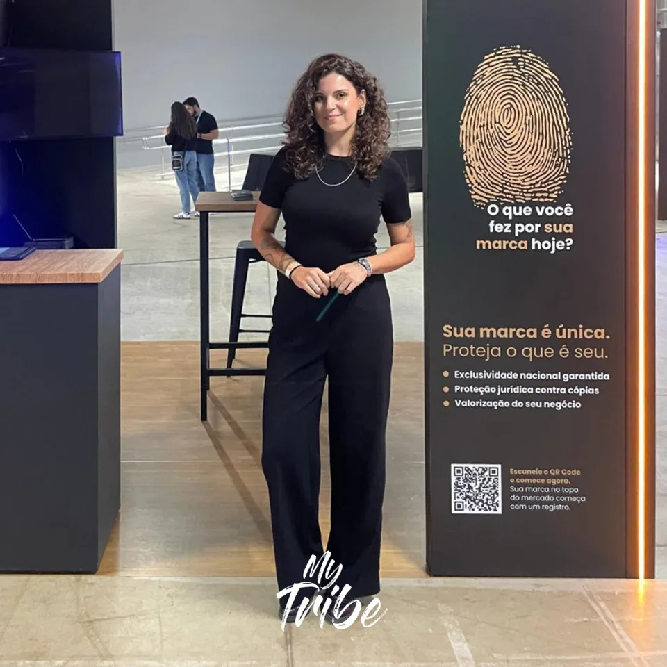 Recepcionista de roupa preta na entrada de um estande em feira de negócios
