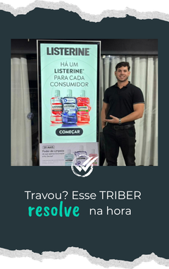 Profissional de suporte técnico ao lado de um totem interativo em evento